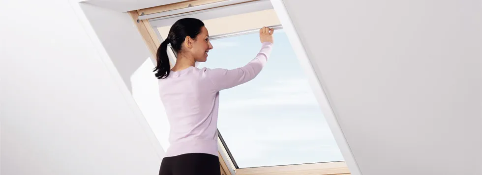 Woman opening window in loft conversion